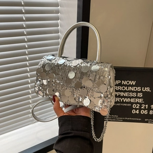 Detail of silver sequin square bag featuring metallic handle and shiny circular texture