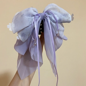 Dettaglio del fermaglio per capelli a fiocco in chiffon viola con nappe di perline