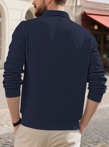 Rear view of navy men's knit pullover with textured waffle jacquard in outdoor setting