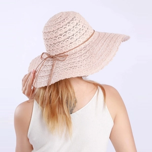 Rear view of a light pink lace sun hat with a wide wavy brim and delicate bow detail