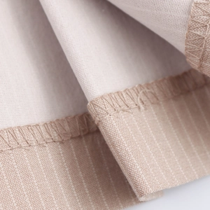 Macro shot of beige striped cotton-linen fabric with professional overlock stitching detail