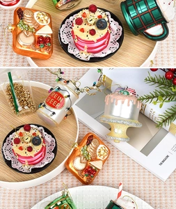 Detailed view of glass Christmas ornaments shaped like beer cans and desserts on a tray