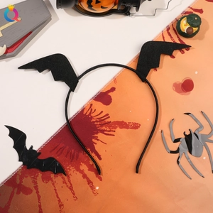 Halloween black felt bat wing headband on orange background with spider and pumpkin props