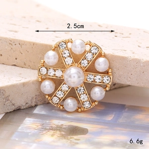 Detailed view of 2.5cm gold flower button with white pearls and sparkling rhinestones