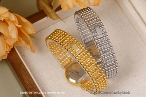 Detailed view of gold and silver luxury beaded watches in a premium wooden gift box