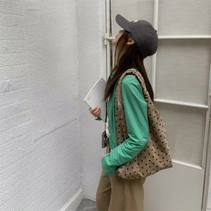 Polka dot velvet tote bag styled with a green shirt for minimalist Korean street style
