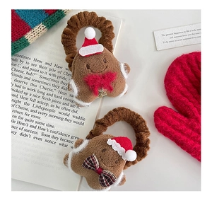 Close-up of plush gingerbread man hair ties with festive red and plaid bows