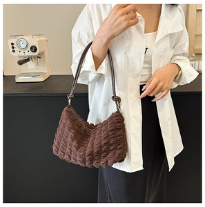 Detail of dark brown textured bubble fabric on a stylish ruched shoulder bag
