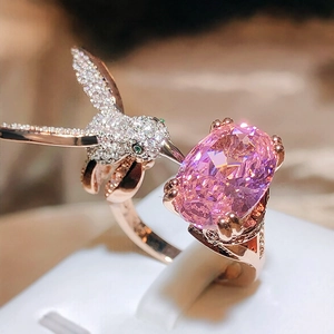 Rose gold hummingbird ring featuring a large oval pink zircon with shimmering micro-diamonds