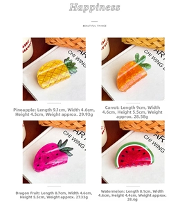 Detailed view of four tropical fruit hair claws including pineapple and watermelon designs