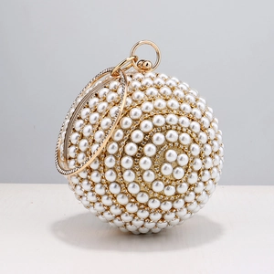 Detail of spherical evening clutch with pearls, rhinestones and golden circular handle