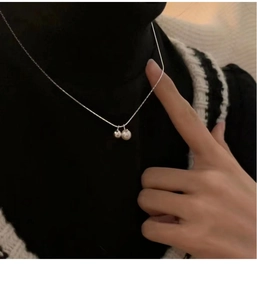 Detail of s925 silver necklace with two polished round beads on a minimalist thin chain