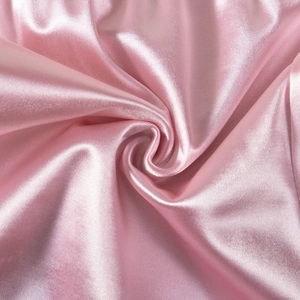 Close-up of pink satin fabric showing its smooth glossy texture and delicate drapes