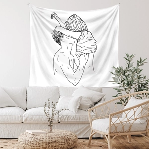 Detail of minimalist line art tapestry featuring a romantic couple on a living room wall