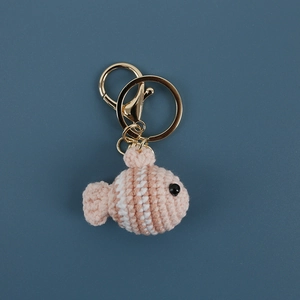 Handmade crochet clownfish keychain in pink and white yarn with a gold metal hook