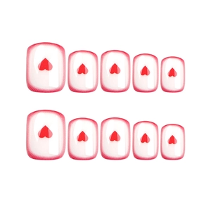 Short square press-on nails with red heart patterns and French red tips on white base