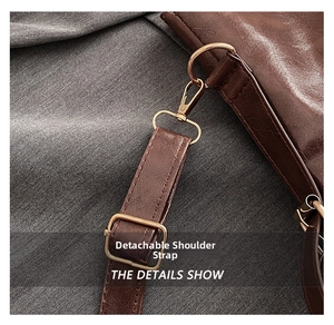 Detail of dark brown leather underarm bag featuring golden metal hooks and adjustable strap