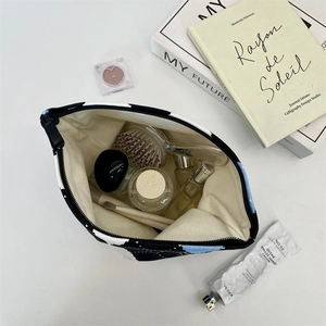 Open checkered makeup bag showing large capacity with brushes and toiletries inside