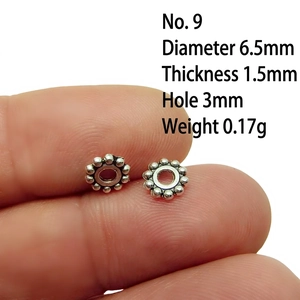 Detail view of a 6.5mm silver alloy spacer bead for DIY jewelry making on white background