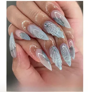 Detail of almond nails with 3D shell relief, silver glitter edges, and small rhinestones