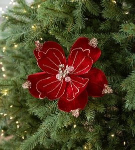 Close-up of a red velvet artificial Christmas magnolia with gold sequins on a tree