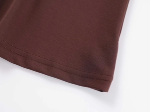 Macro detail of brown knitted yoga top featuring precision double-needle hem stitching