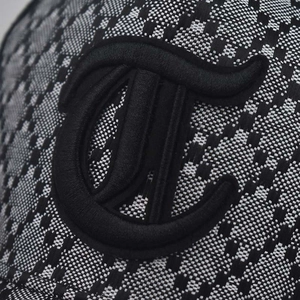 Macro shot of black and white plaid baseball cap fabric with 3D letter embroidery