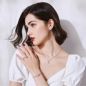 Close-up of elegant silver jewelry set with halo design worn by a professional model
