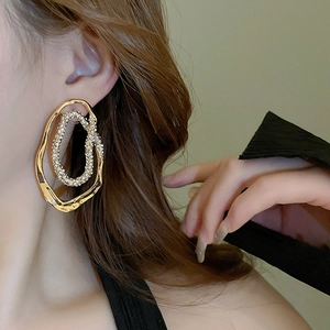 Golden geometric hollow earrings with sparkling rhinestones on female model