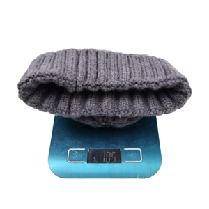 Berretto in maglia grigio scuro con pompon rimovibile che pesa circa 105g sulla bilancia