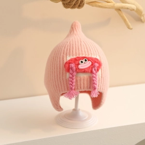 Detailed knit texture of pink baby winter hat with earflaps and cute cartoon face