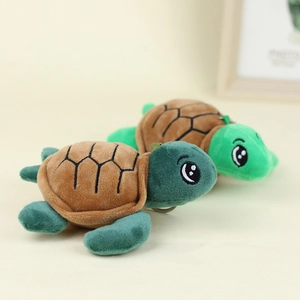 Plush sea turtle toy set with green limbs and brown shell on a clean beige background