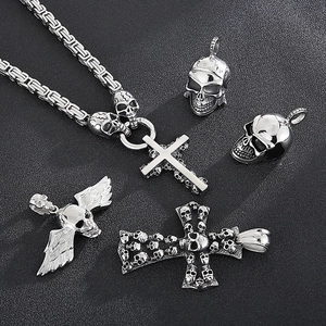 Detailed macro view of assorted gothic skull and cross stainless steel pendants for men