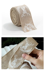 Detailed view of burlap Christmas ribbon featuring white reindeer prints for gift wrapping