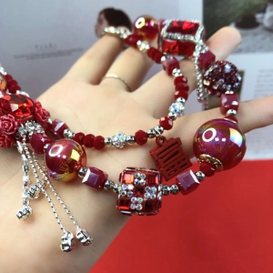 Detail of red beaded Chinese style necklace with silver double joy charm and tassels