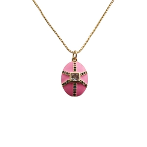 Détail d'un pendentif croix plaqué or avec émail rose et pierres colorées sur un collier