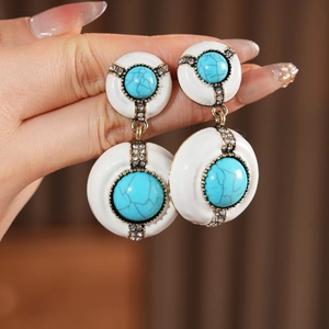 Detail of vintage round drop earrings with white enamel and turquoise stones
