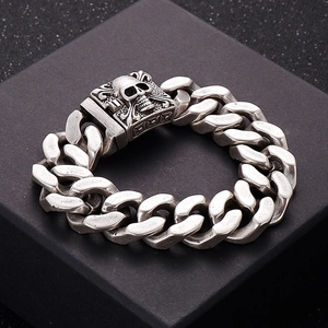 Detailed macro shot of vintage silver cuban chain link bracelet with skull clasp on black box