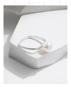Detailed view of an S925 silver square ring with a white pearl on a textured stone
