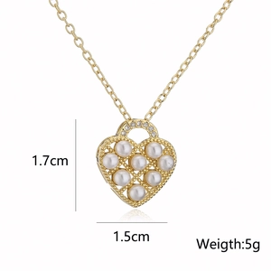 Detail view of 18K gold heart pendant dimensions 1.7x1.5cm with pearl and zircon inlay