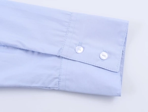 Detailed macro view of light blue poplin shirt cuff with dual white button closure