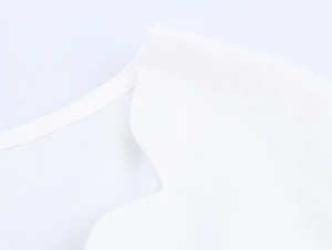Détail du col en dentelle ondulée blanche et texture brodée en coton et lin