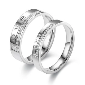 Macro shot of silver stainless steel rings with LOVE engraving and white zircon inlay