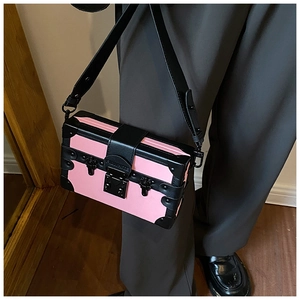 Detail of pink and black crossbody box bag with metal rivets and PINKWHITE buckle