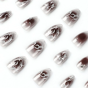 Short teardrop press-on nails with dark brown gradient, white lines and rhinestones