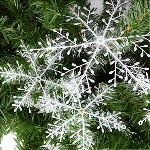 White plastic snowflake ornaments with brushed texture hanging on a Christmas tree