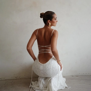 Détail de la robe blanche dos nu avec fines bretelles et laçage croisé au dos