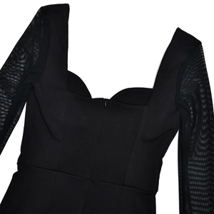 Detail of a black bodycon dress featuring a heart neckline and mesh long sleeves