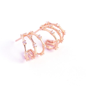 Detail of rose gold triple-layer bamboo earrings with micro-pave white zircon stones