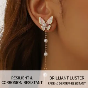 Detail of pink and green enamel butterfly earring with elegant hanging white pearls